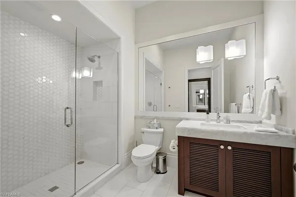 a bathroom with a granite countertop sink a toilet and shower