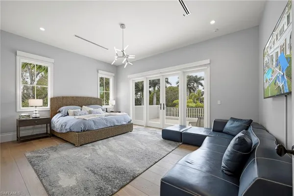 a spacious bedroom with a bed couch and a large window