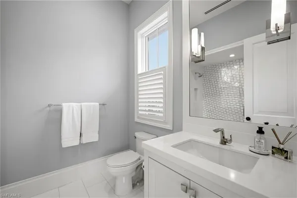 a bathroom with a sink a toilet and a mirror