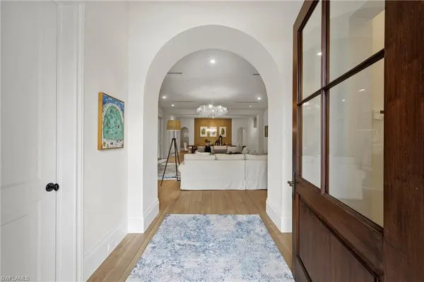 a view of a hallway view with living room and wooden floor