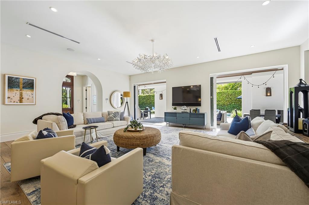 215 3rd Avenue North Naples, FL 34102 - Photo 6 of 47 Living room featuring hanging lights, arched walkways, plenty of natural light, and wood finished floors