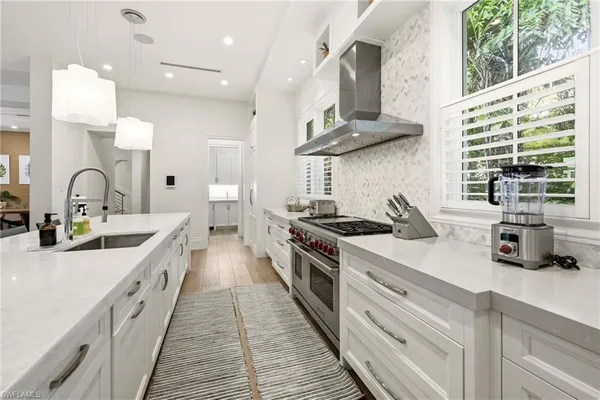 a kitchen with stainless steel appliances a sink stove and cabinets