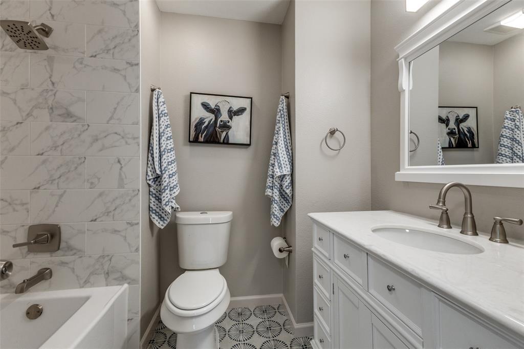 3406 Blue Ridge Lane Garland, TX 75042 - Photo 21 of 25 a bathroom with a granite countertop toilet a sink and a bathtub