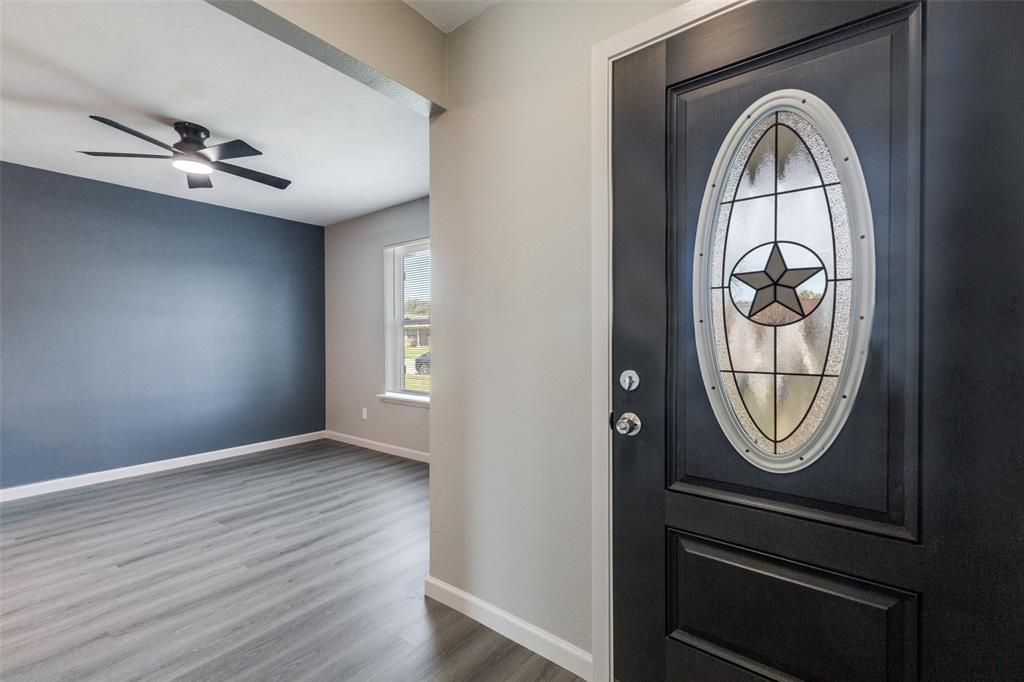 3406 Blue Ridge Lane Garland, TX 75042 - Photo 4 of 25 an empty room with wooden floor mirror and windows