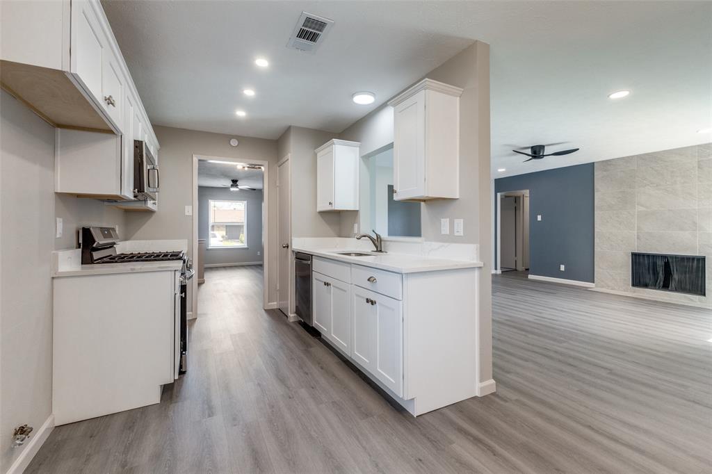 3406 Blue Ridge Lane Garland, TX 75042 - Photo 5 of 25 a kitchen with a sink stainless steel appliances and cabinets