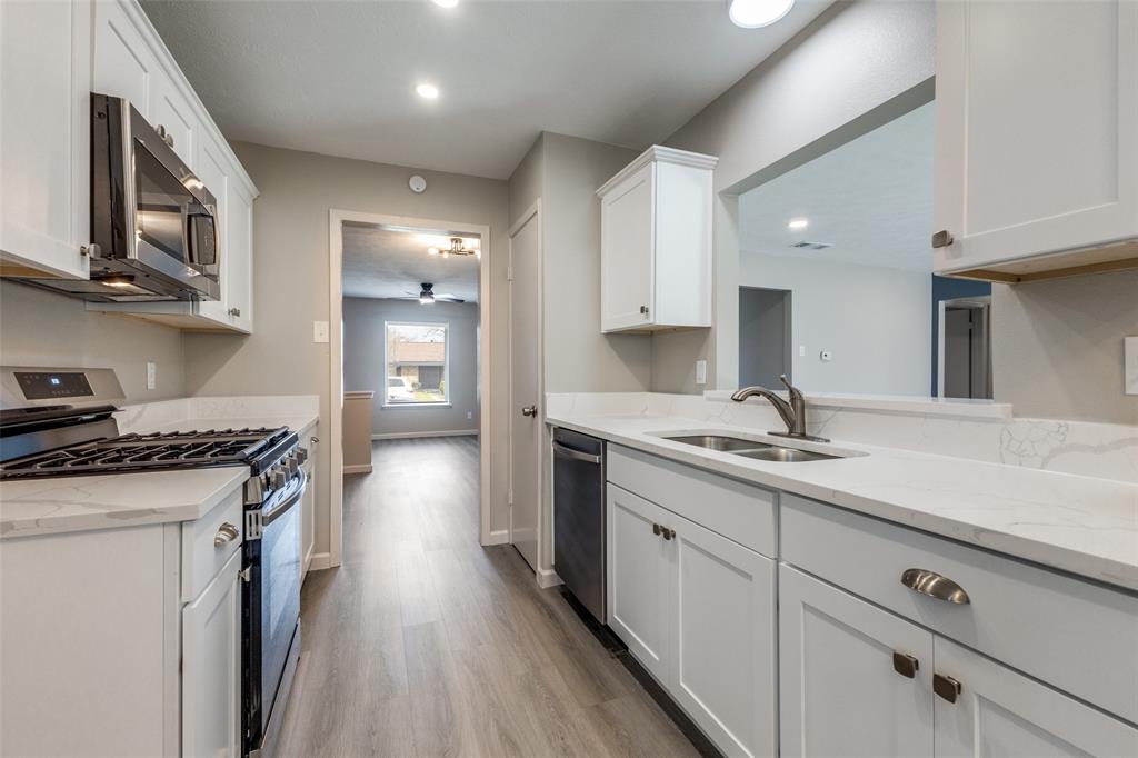 3406 Blue Ridge Lane Garland, TX 75042 - Photo 6 of 25 a kitchen with a sink stove and cabinets