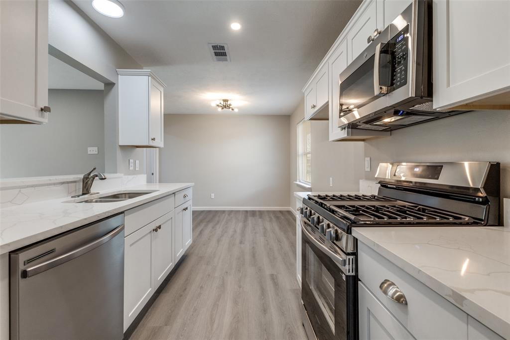 3406 Blue Ridge Lane Garland, TX 75042 - Photo 7 of 25 a kitchen with stainless steel appliances a sink stove and cabinets