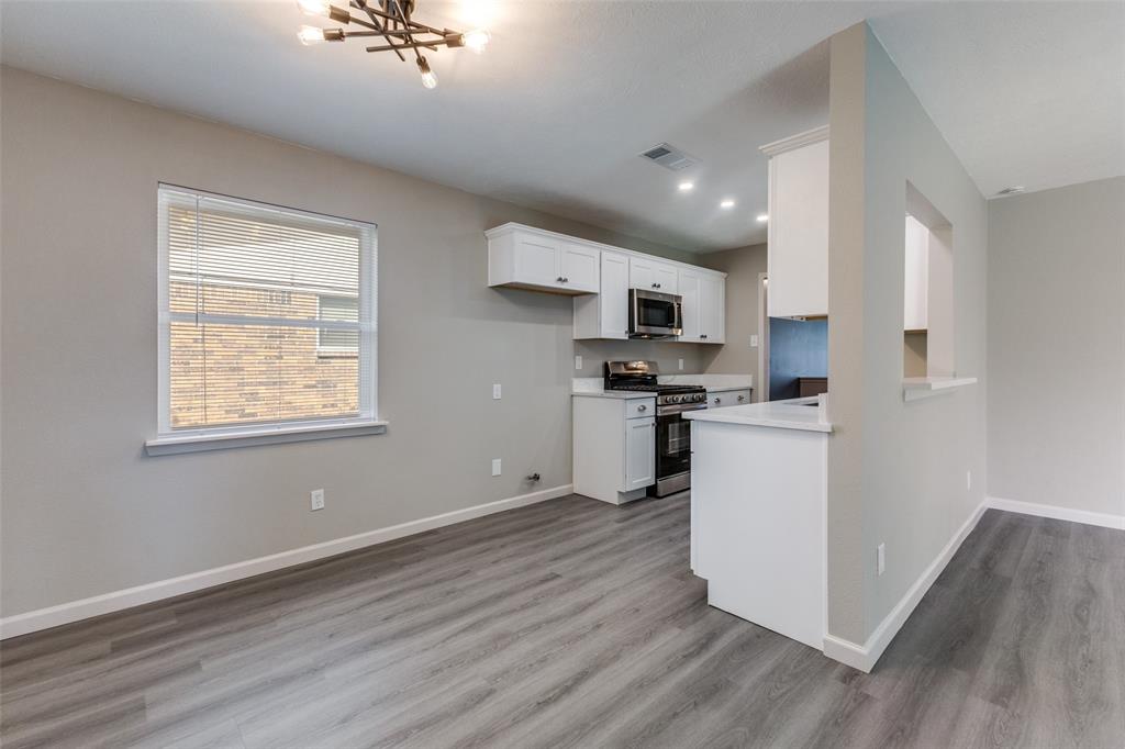 3406 Blue Ridge Lane Garland, TX 75042 - Photo 8 of 25 a kitchen with kitchen island wooden floors appliances and cabinets