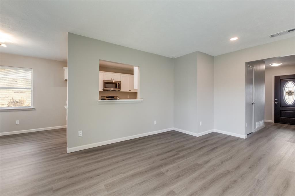 3406 Blue Ridge Lane Garland, TX 75042 - Photo 9 of 25 an empty room with wooden floor and windows