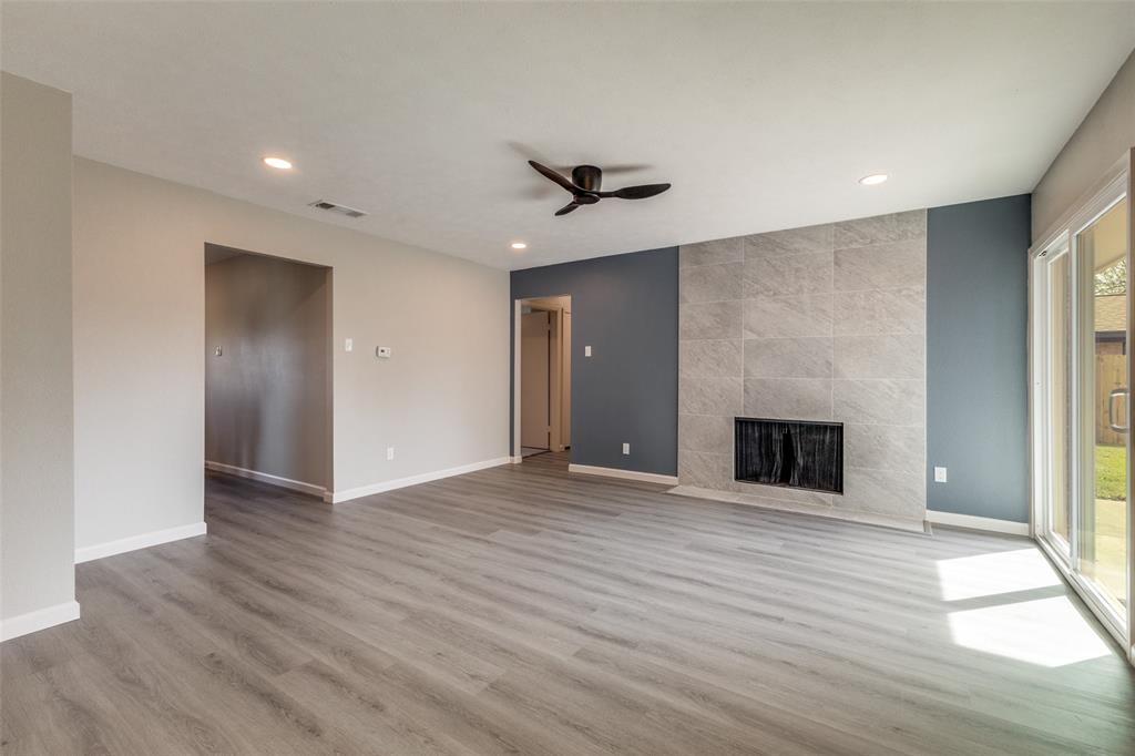 3406 Blue Ridge Lane Garland, TX 75042 - Photo 10 of 25 a view of an empty room with wooden floor fireplace and a window