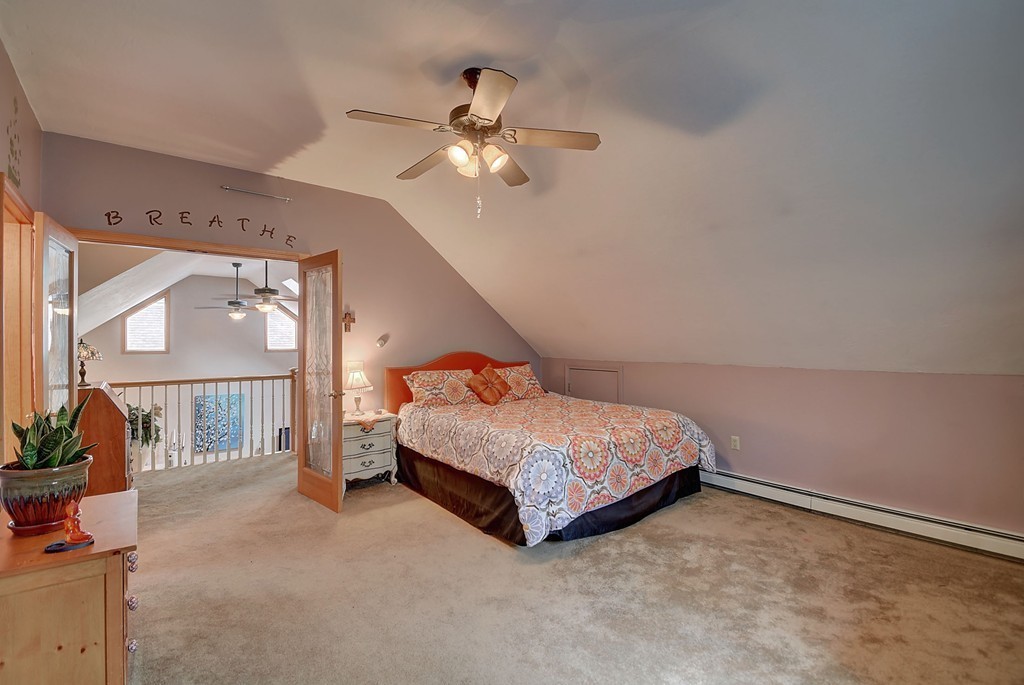 126 Wales Road Holland, MA 01521 - Photo 23 of 24 a spacious bedroom with a bed a chandelier and a window