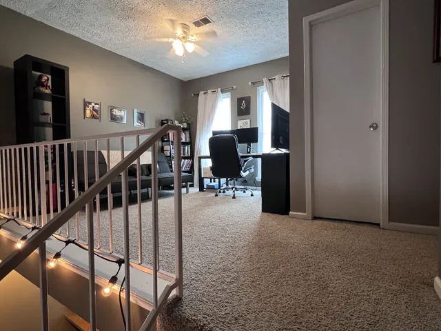 a view of a livingroom with furniture and stairs