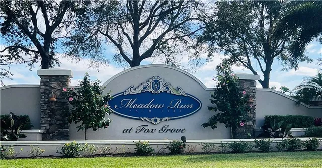 a front view of a house with a garden and tree