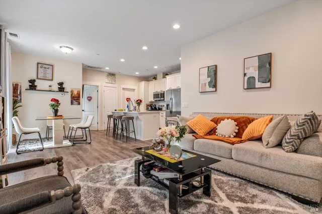 a living room with furniture and kitchen view