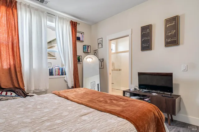 a bedroom with a bed and a flat screen tv