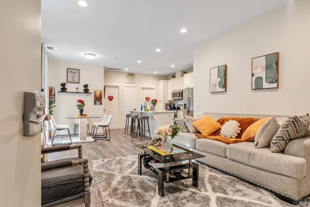 a living room with furniture and a view of kitchen