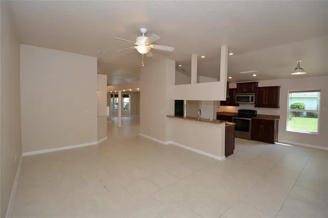 a kitchen with stainless steel appliances kitchen island granite countertop a refrigerator and a stove top oven