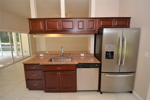 a kitchen with granite countertop wooden cabinets and stainless steel appliances