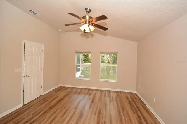 a view of an empty room with wooden floor