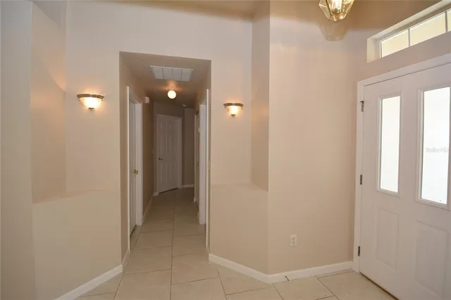 a view of an empty room with closet and a window