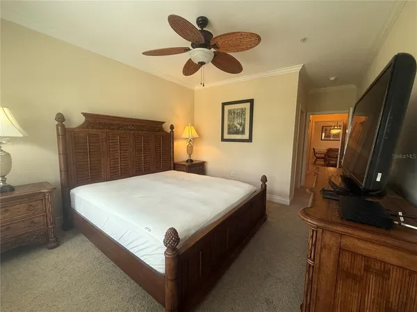 a bed sitting in a bedroom and a flat screen tv