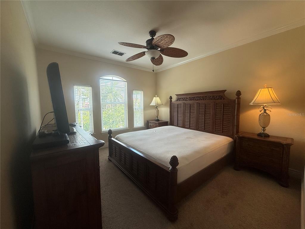 2715 Via Capri, Unit 732 Clearwater, FL 33764 - Photo 13 of 31 a bedroom with a bed and a chandelier