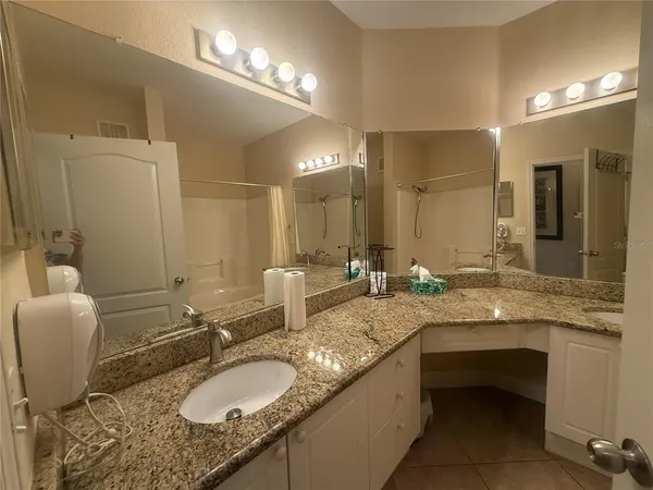 a bathroom with a granite countertop sink a mirror and a toilet