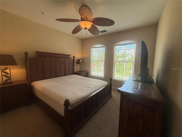 a bed sitting in a spacious bedroom next to a window