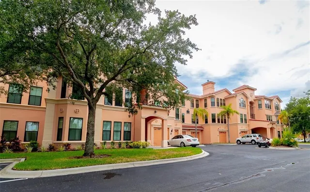 a front view of a residential apartment building with yard and green space