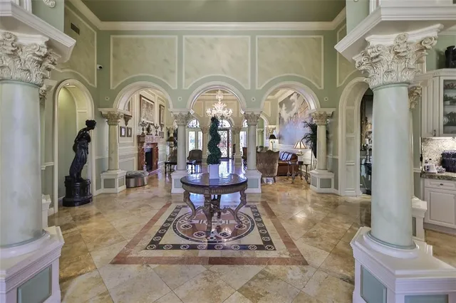 a living room with fireplace chandelier and a rug