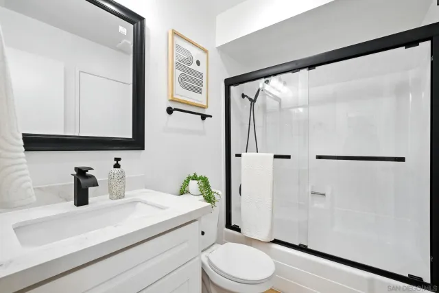 a bathroom with a sink a toilet and shower