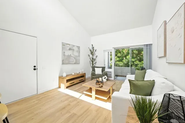 a living room with furniture a large window and a wooden floor