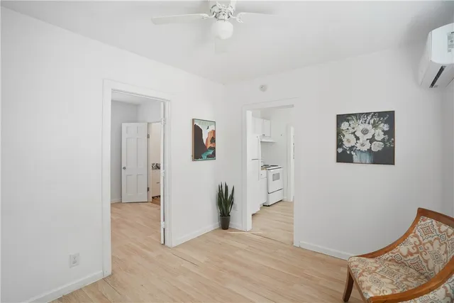 a view of a livingroom with wooden floor and a ceiling fan