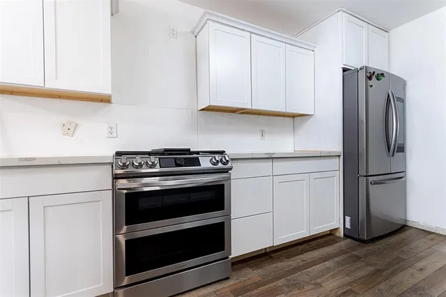 a kitchen with stainless steel appliances white cabinets and a refrigerator