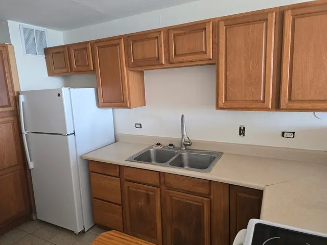 a kitchen with a sink cabinets and refrigerator