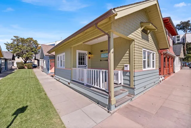 a view of a house with a small yard and wooden fence