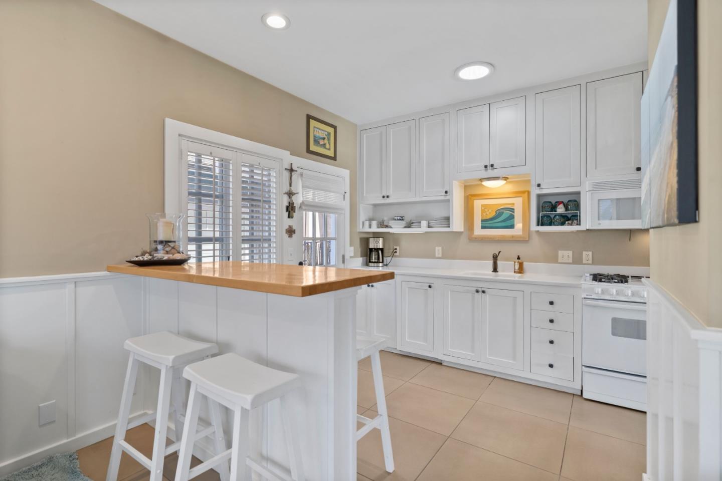 106 Lawn Way Capitola, CA 95010 - Photo 7 of 21 a kitchen with granite countertop white cabinets white appliances with a sink and dishwasher