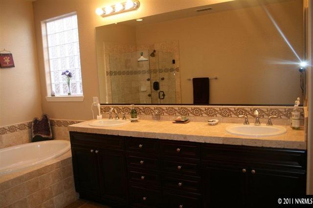 9280 Lost Valley Road Reno, NV 89521 - Photo 8 of 13 a bathroom with a granite countertop sink a large mirror and a bathtub