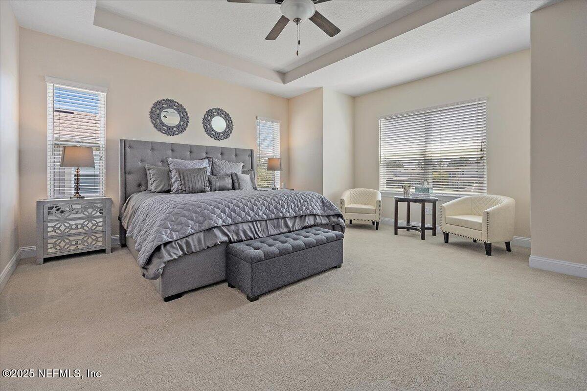 166 Portside Avenue Ponte Vedra, FL 32081 - Photo 19 of 46 a bedroom with a bed a chandelier and a couch