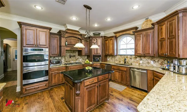 a kitchen with stainless steel appliances granite countertop a sink stove and refrigerator