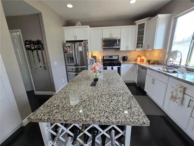 a kitchen with stainless steel appliances granite countertop a sink stove microwave and refrigerator