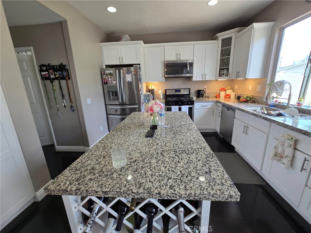 1315 Plaza Way Perris, CA 92570 - Photo 12 of 37 a kitchen with stainless steel appliances granite countertop a sink stove microwave and refrigerator