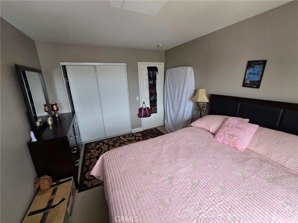 1315 Plaza Way Perris, CA 92570 - Photo 16 of 37 a bedroom with a bed a mirror and a chair