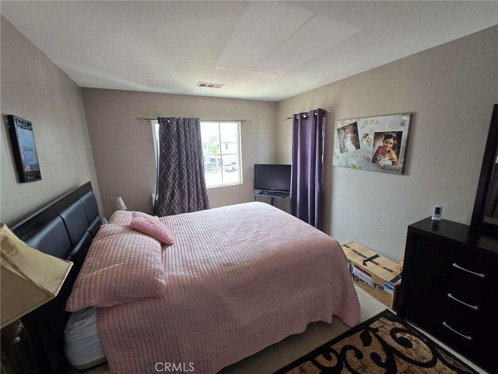 1315 Plaza Way Perris, CA 92570 - Photo 24 of 37 a bedroom with a bed and wooden floor