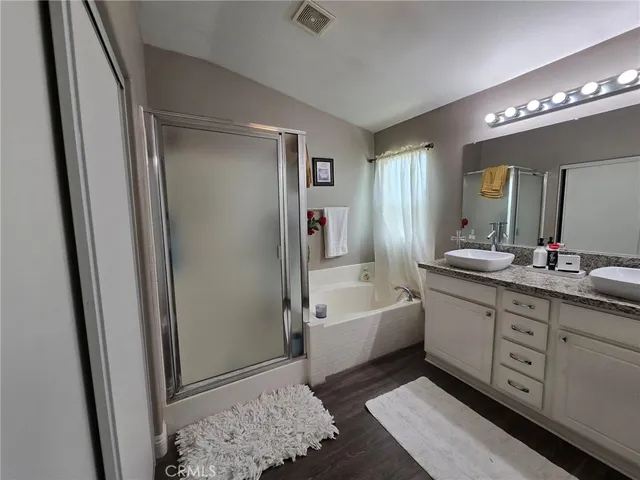 a spacious bathroom with a double vanity sink a mirror and a bathtub