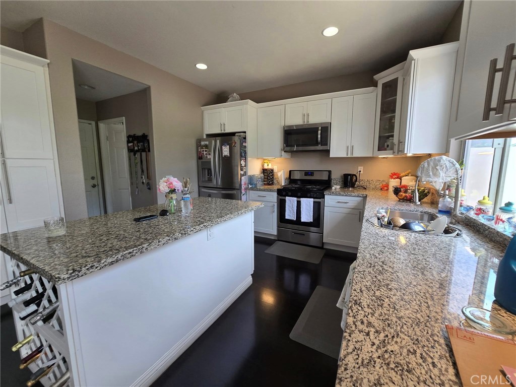 1315 Plaza Way Perris, CA 92570 - Photo 10 of 37 a kitchen with stainless steel appliances granite countertop a sink stove refrigerator and cabinets