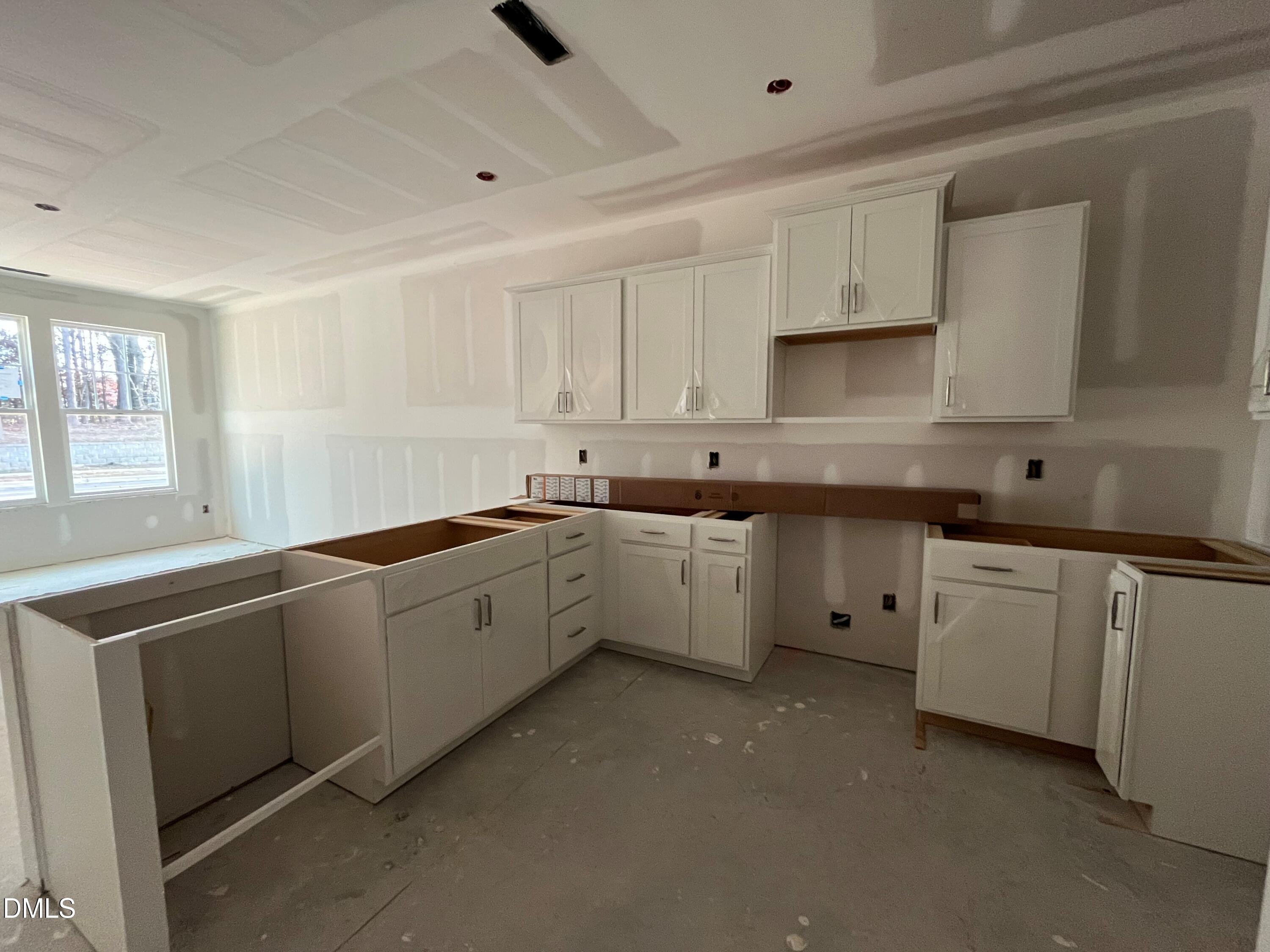 6423 Granite Quarry Drive Raleigh, NC 27610 - Photo 5 of 49 a large white kitchen with white cabinets