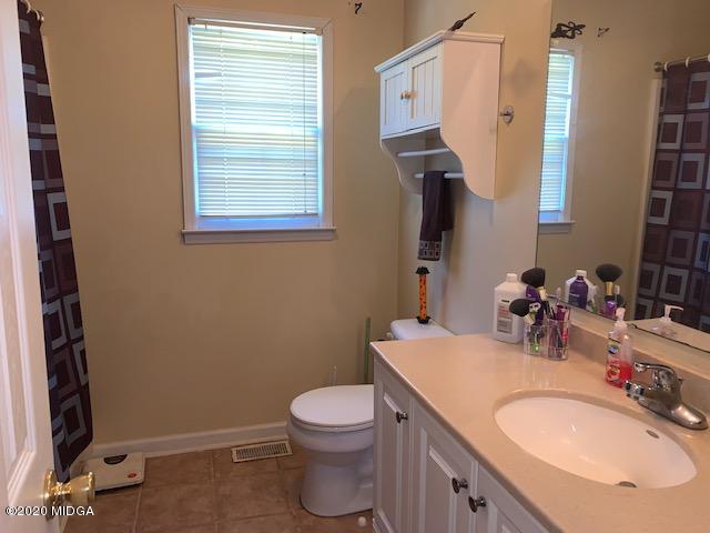747 Gose Road Forsyth, GA 31029 - Photo 12 of 15 a bathroom with a granite countertop toilet sink and mirror