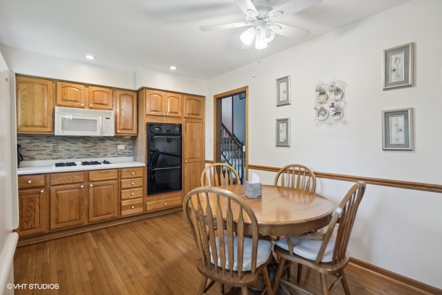 7631 Apple Tree Lane Willowbrook, IL 60527 - Photo 11 of 24 a kitchen with granite countertop a table chairs stove and cabinets
