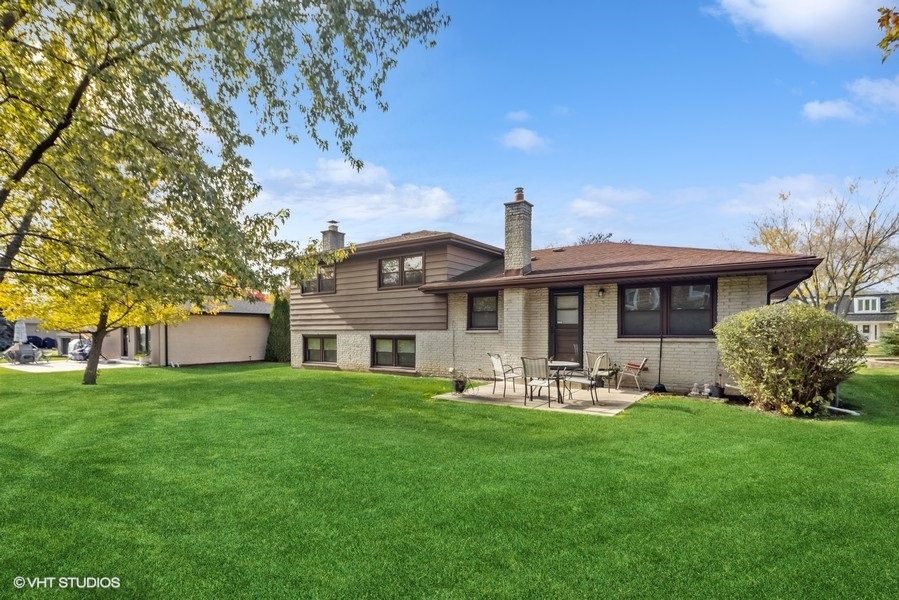 7631 Apple Tree Lane Willowbrook, IL 60527 - Photo 2 of 24 a front view of a house with a garden and trees